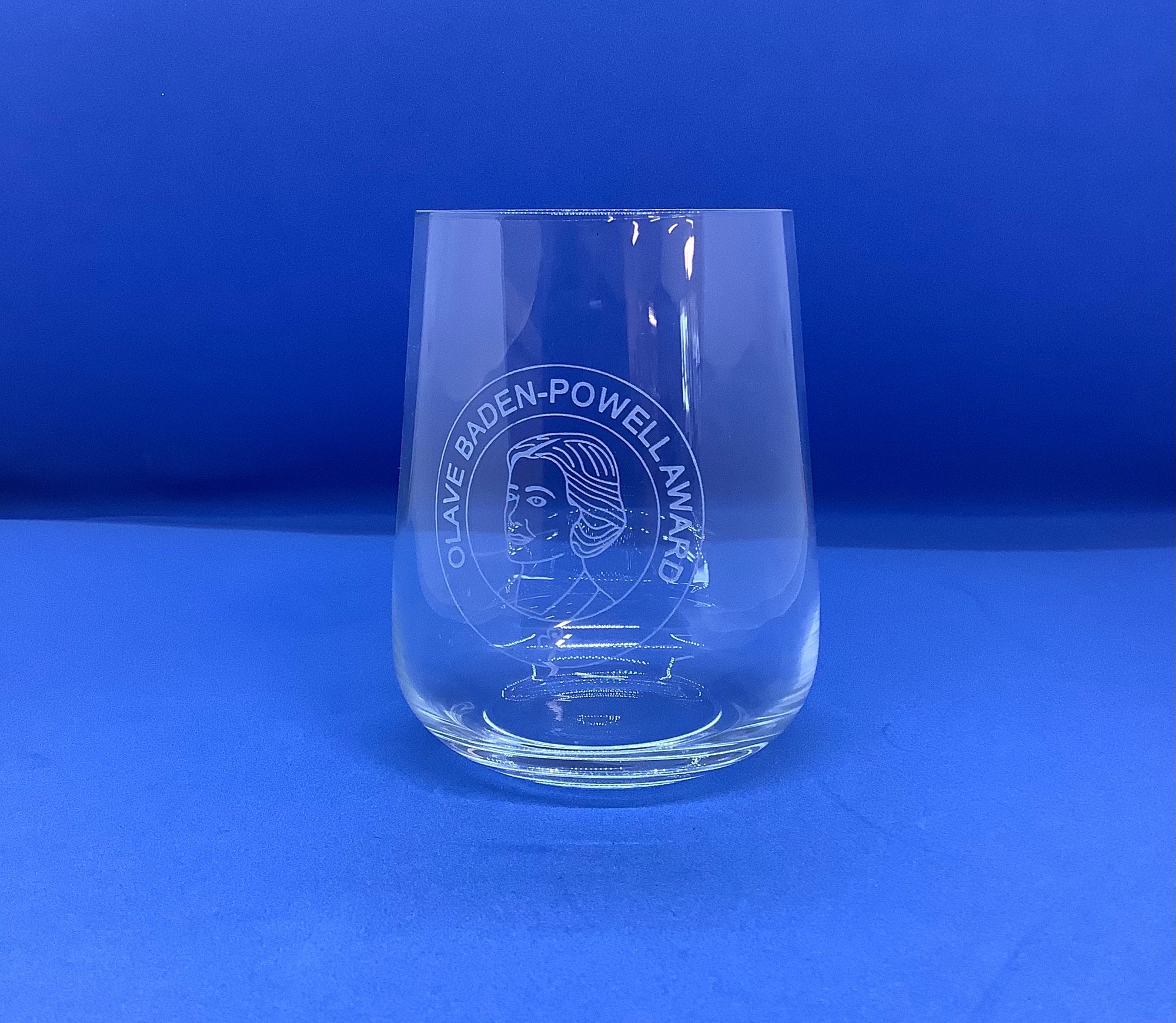 a small glass tumbler with OBP award etched into the glass