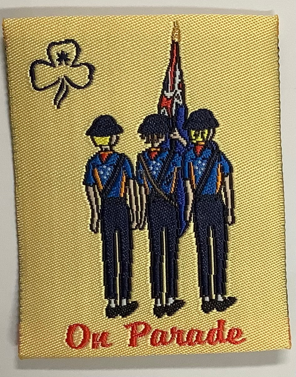 a square unbound badge with a yellow background wit three guides and an Australian flag