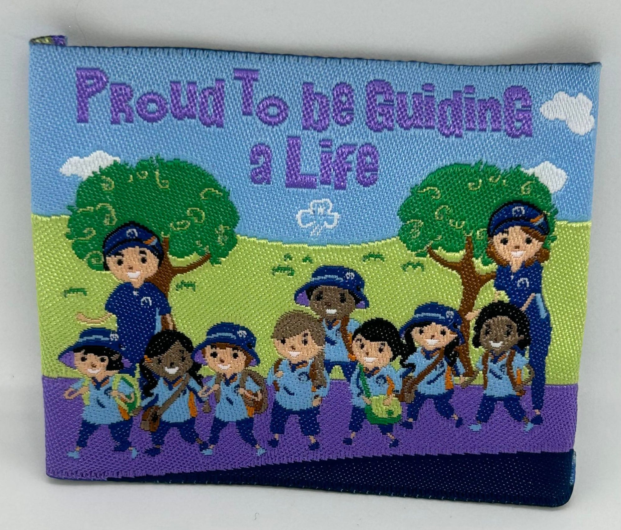 a square unbound badge in an outdoor scene with two guide leaders and a guide unit