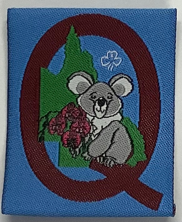 a square unbound badge that is blue with a maroon Q, a map of QLD and a koala