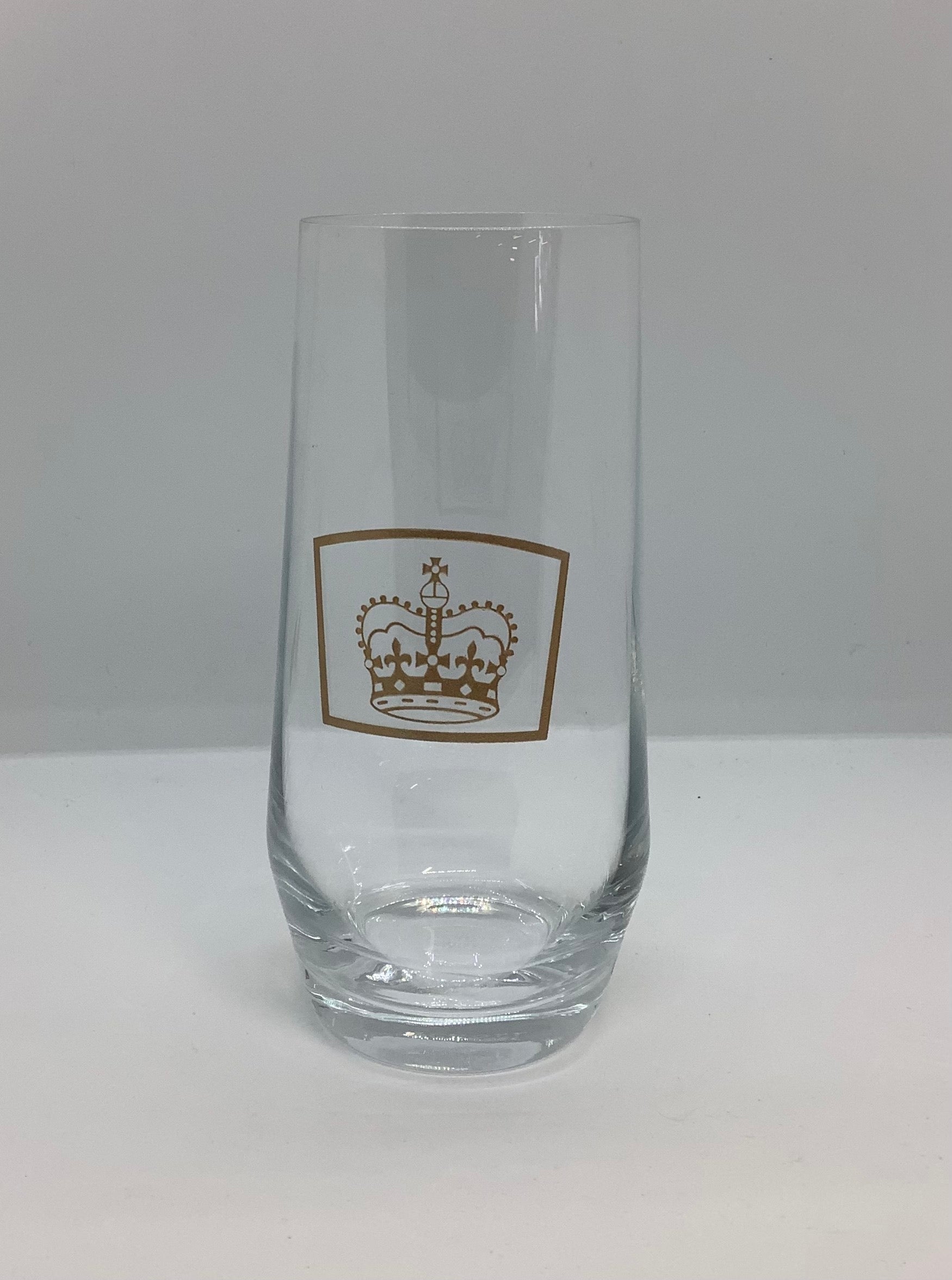 a clear glass tumbler with a gold crown on the front