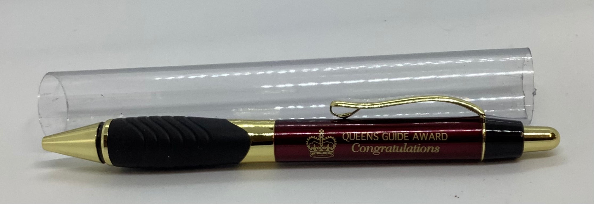 a maroon, black and gold pen with queens guide award congratulations written on it