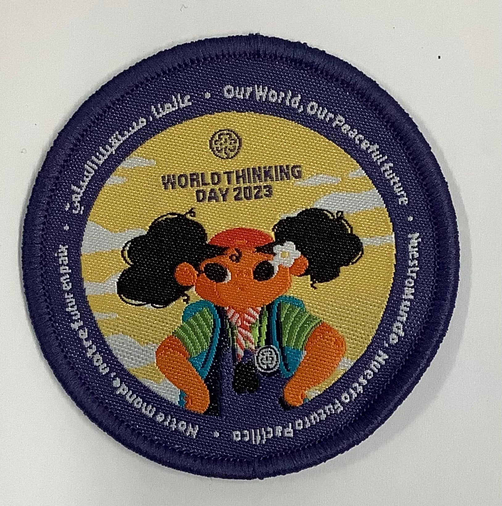 a round badge bound in blue with a girl in the outdoors