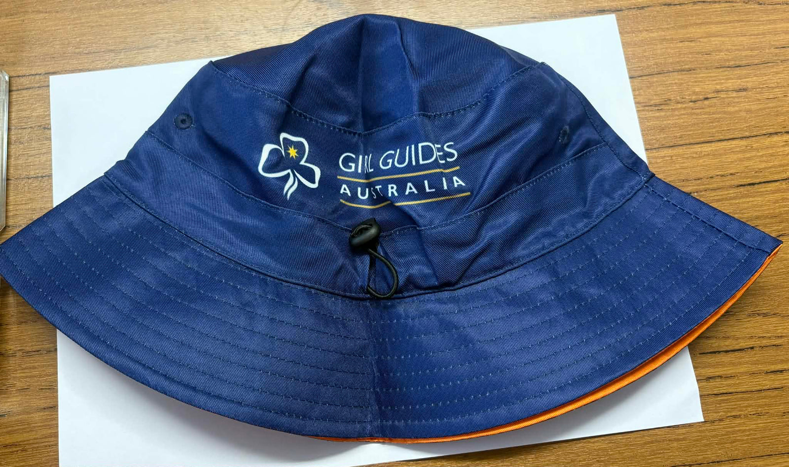 Blue bucket hat with 'Girl Guides Australia' logo and B2B branding on the blue side. On the range side there are pictures of the mascots Echo and Tilly