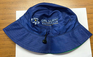 Blue bucket hat with Girl Guides Australia logo with a green reversible side with a kangaroo and dolphin pattern