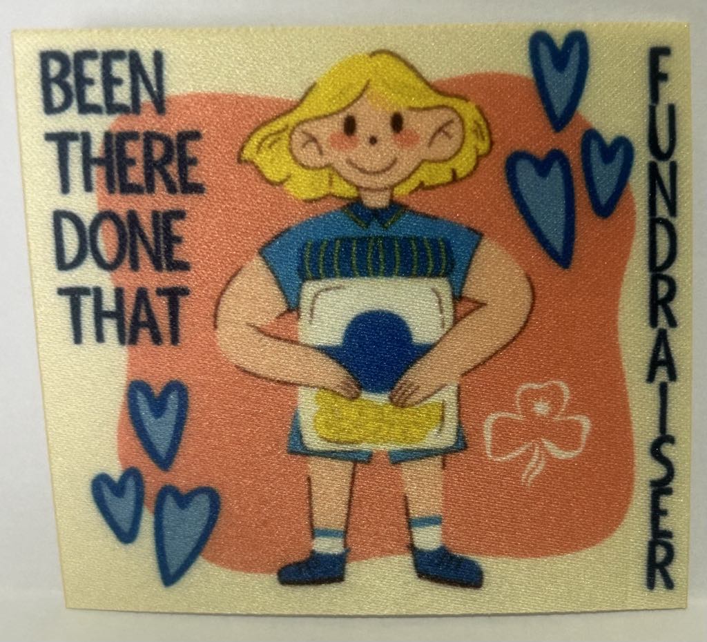 a square unbound badge with a yellow background with a guide holding a jar with coins in it with the words been there done that fundraiser in navy