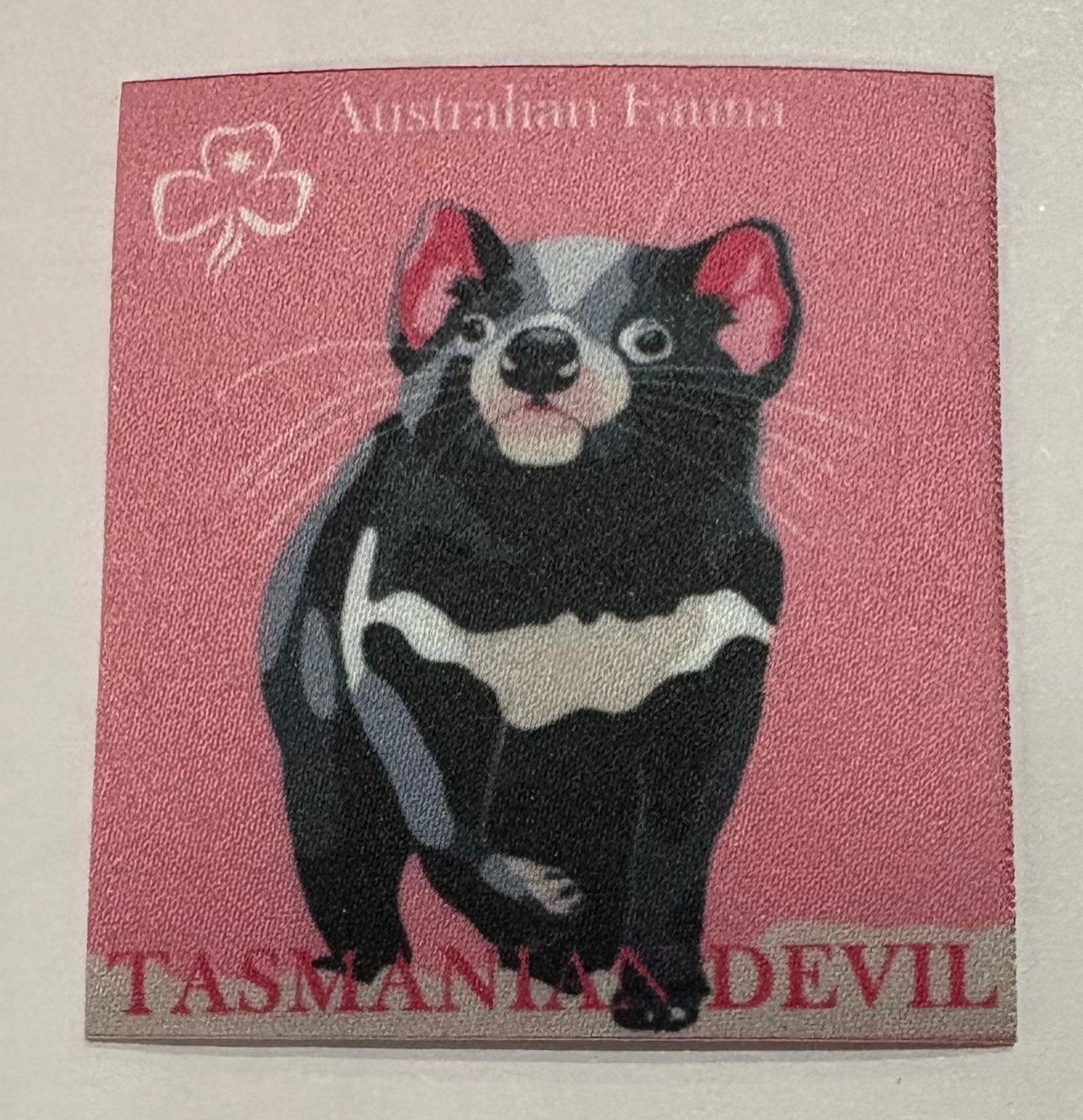A square unbound pink badge with a Tasmanian devil