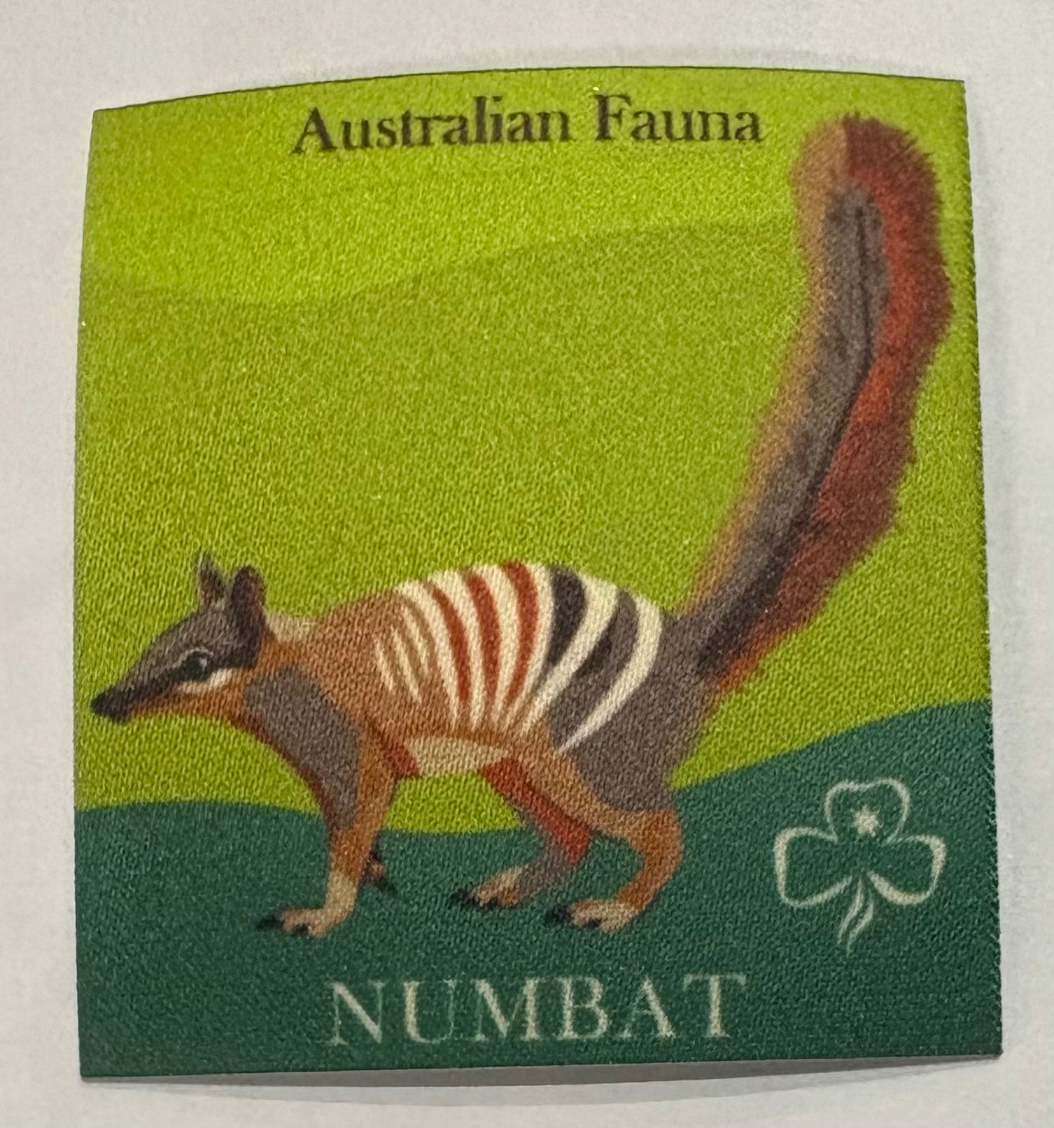 A square unbound green badge with a numbat