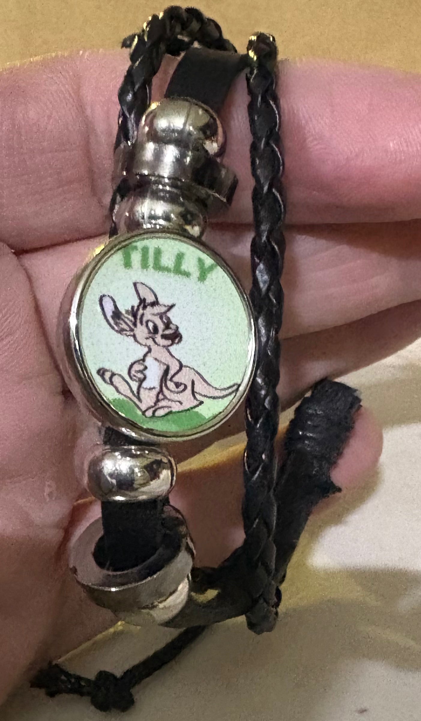 A faux leather bracelet with a disc with Tilly on it
