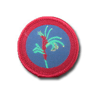 a round badge bound in red with a kangaroo paw flower on it