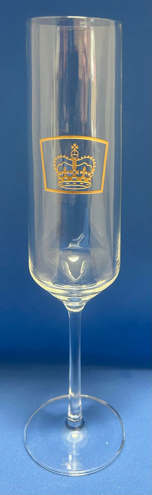 a champagne flute with the queens guide emblem etched in gold