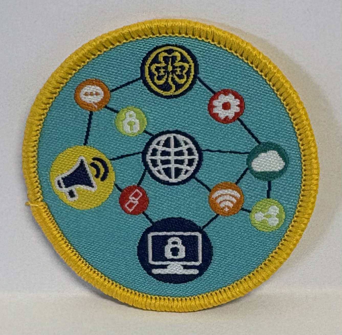Circular badge with various icons on a blue background bound in yellow