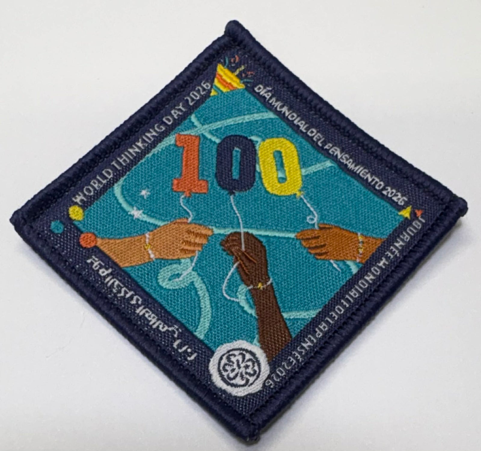 square bound badge for WTD 2026 with the number 100 and three hands and a trefoil