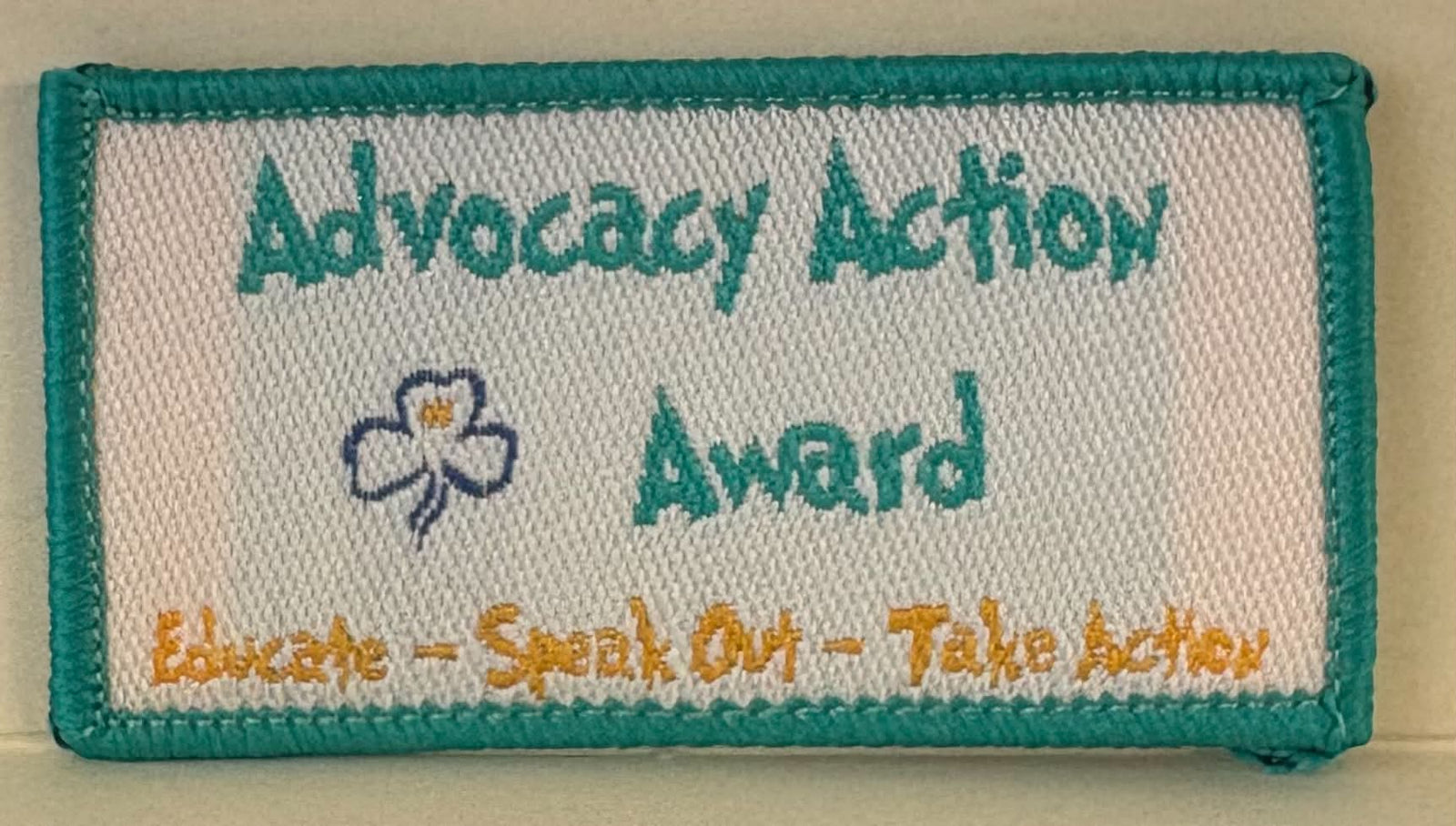 a rectangular bound badge with the words advocacy action award and educate - speak out - take action