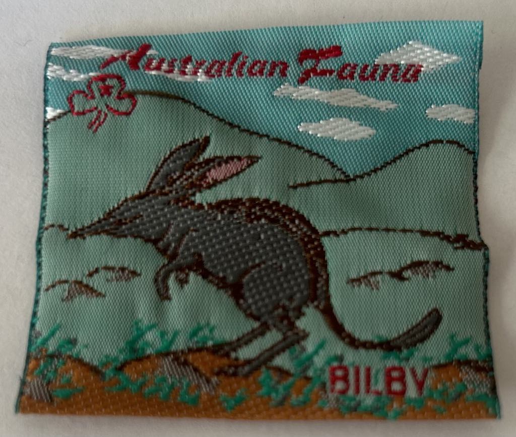 a square unbound badge with a billy and some mountains in the background