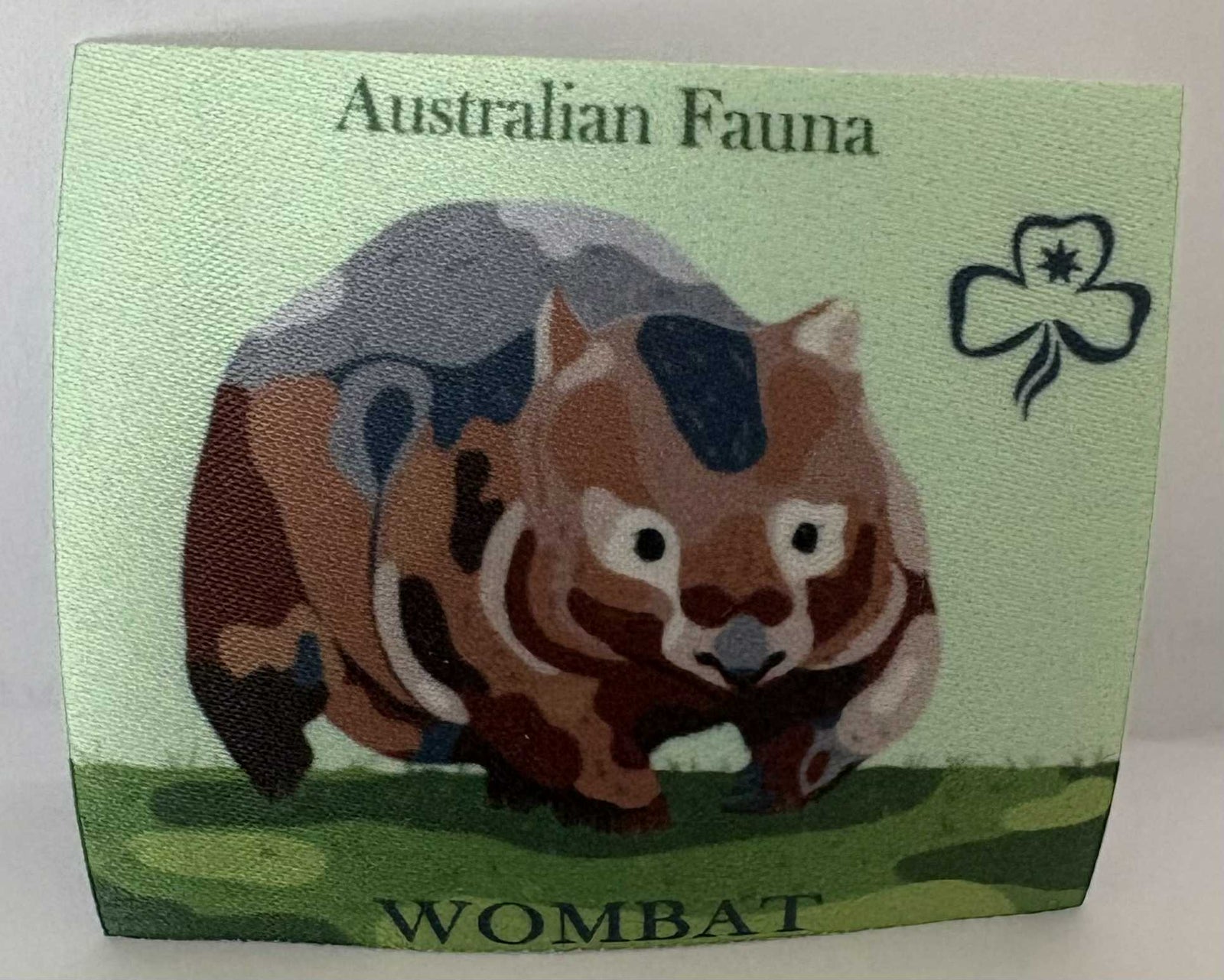 a square unbound badge with a wombat with 'Australian Fauna' text and a trefoil symbol on a green background.