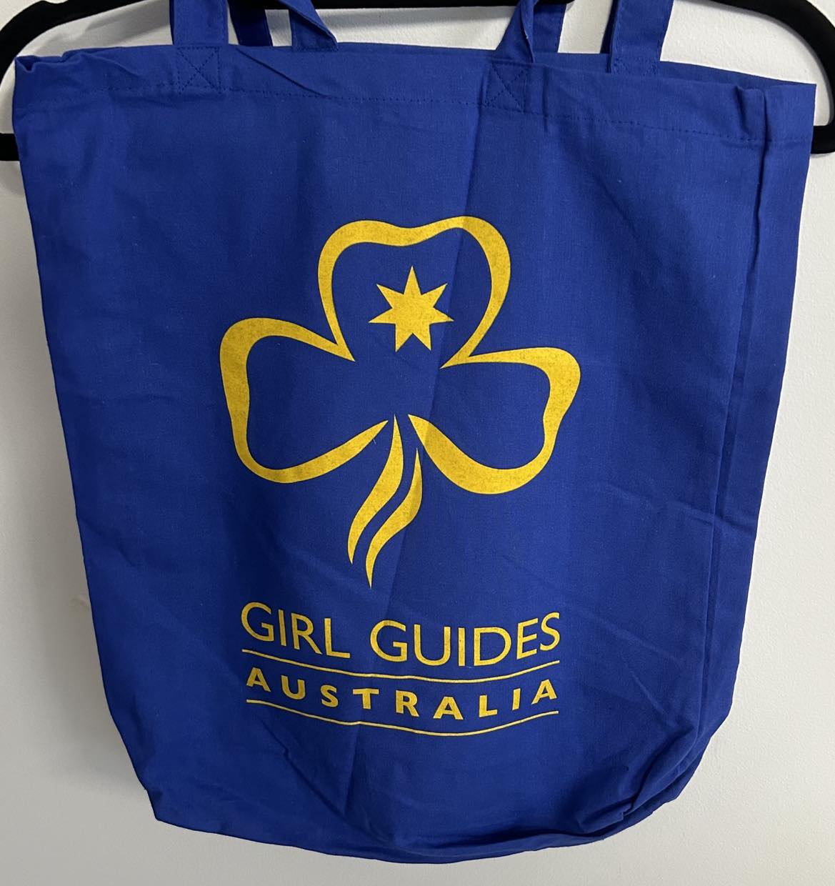 a blue shoulder bag with the trefoil and girl guides Australia written on it