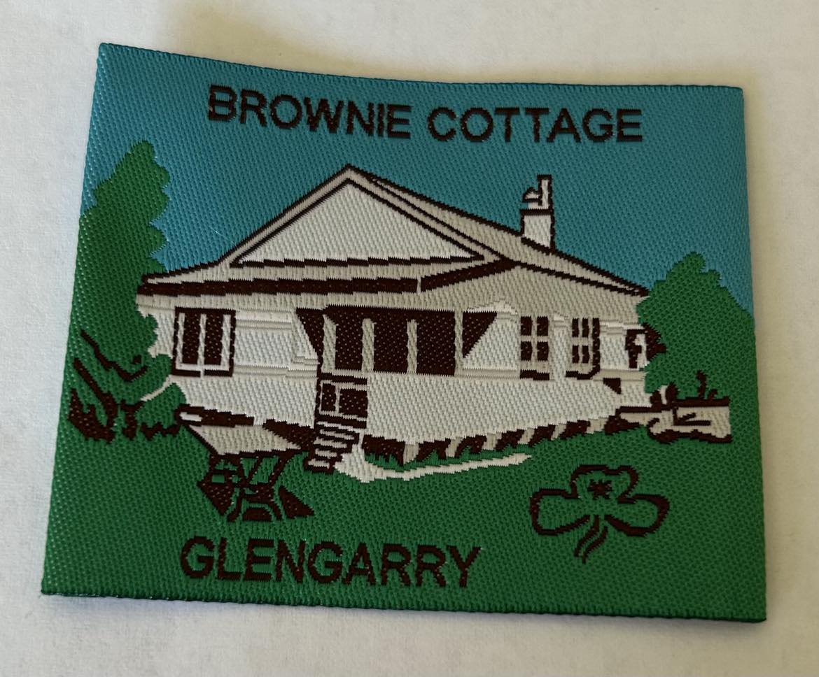 a square unbound badge with a picture of brownie cottage