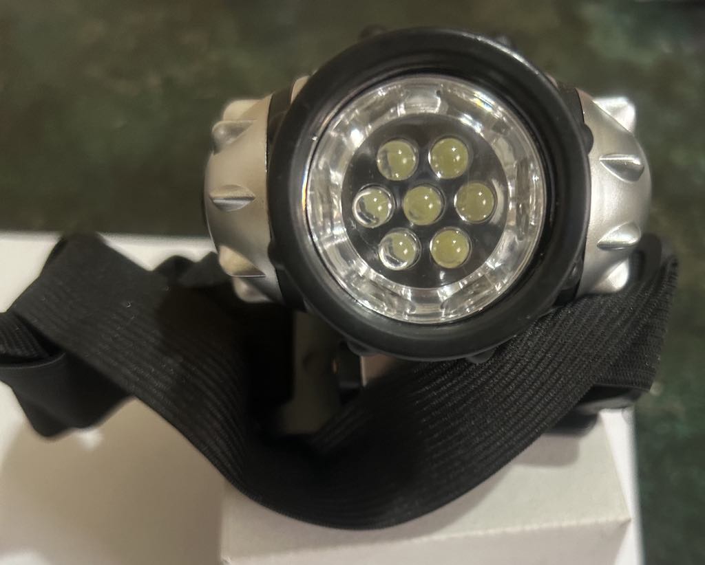 a silver head torch with a black band