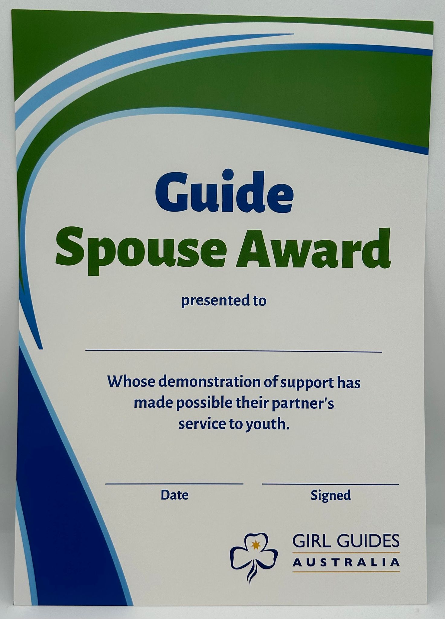 a white A4 certificate with green and blue swirls  that recognises spousal support of someones service to guides 