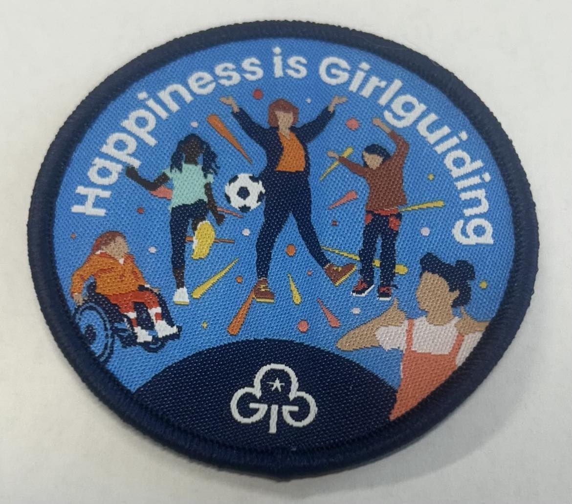 a round badge bound in blue with 5 girls on it it 