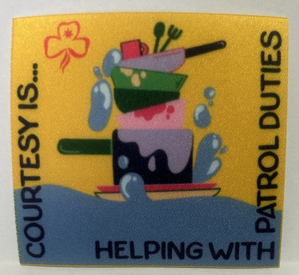a square unbound badge with a yellow and blue background with a pile of dirty dishes with the words courtesy is helping with patrol duties