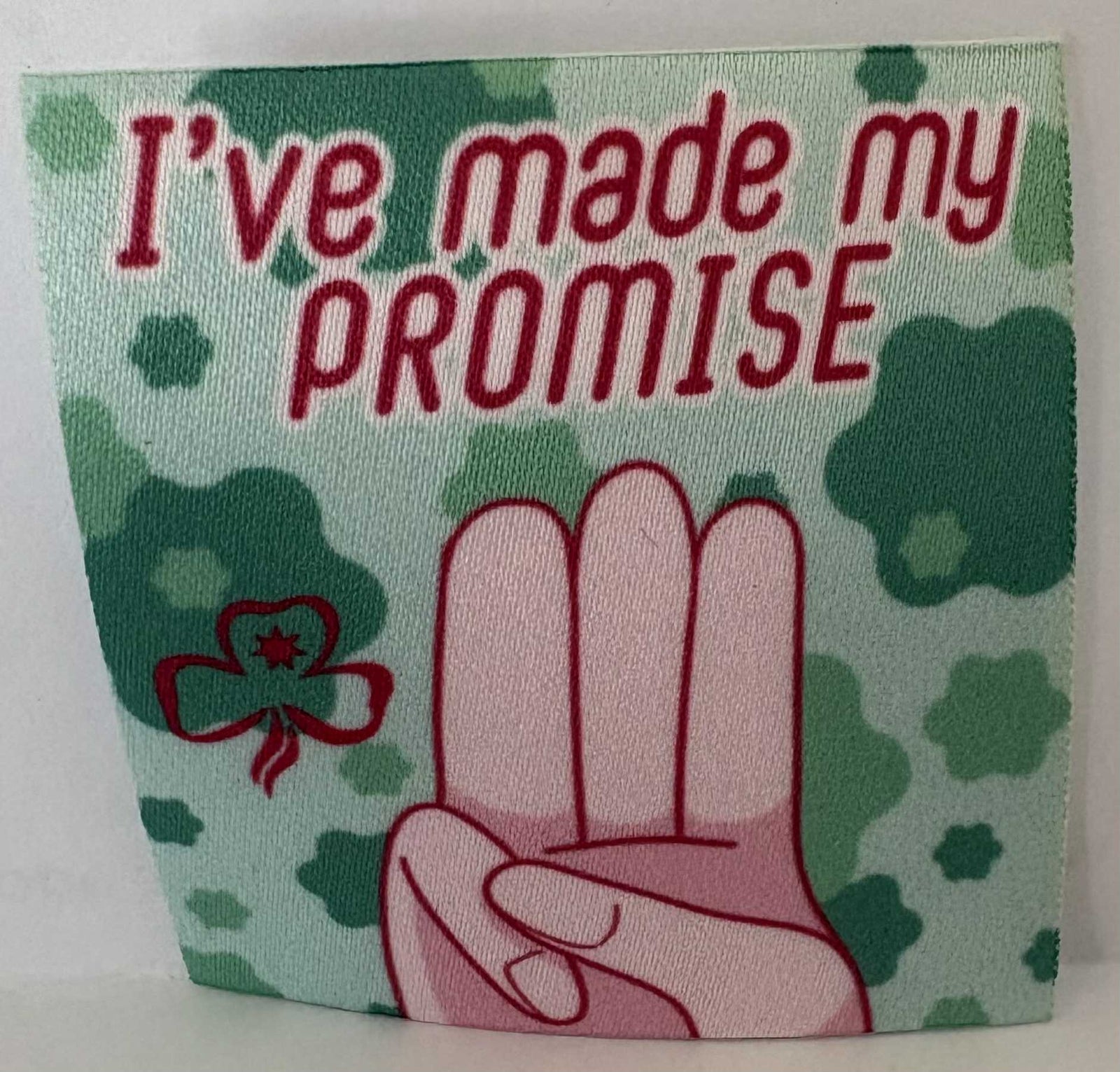 a square unbound badge with red text 'I've made my promise' and a red hand on a green patterned background.