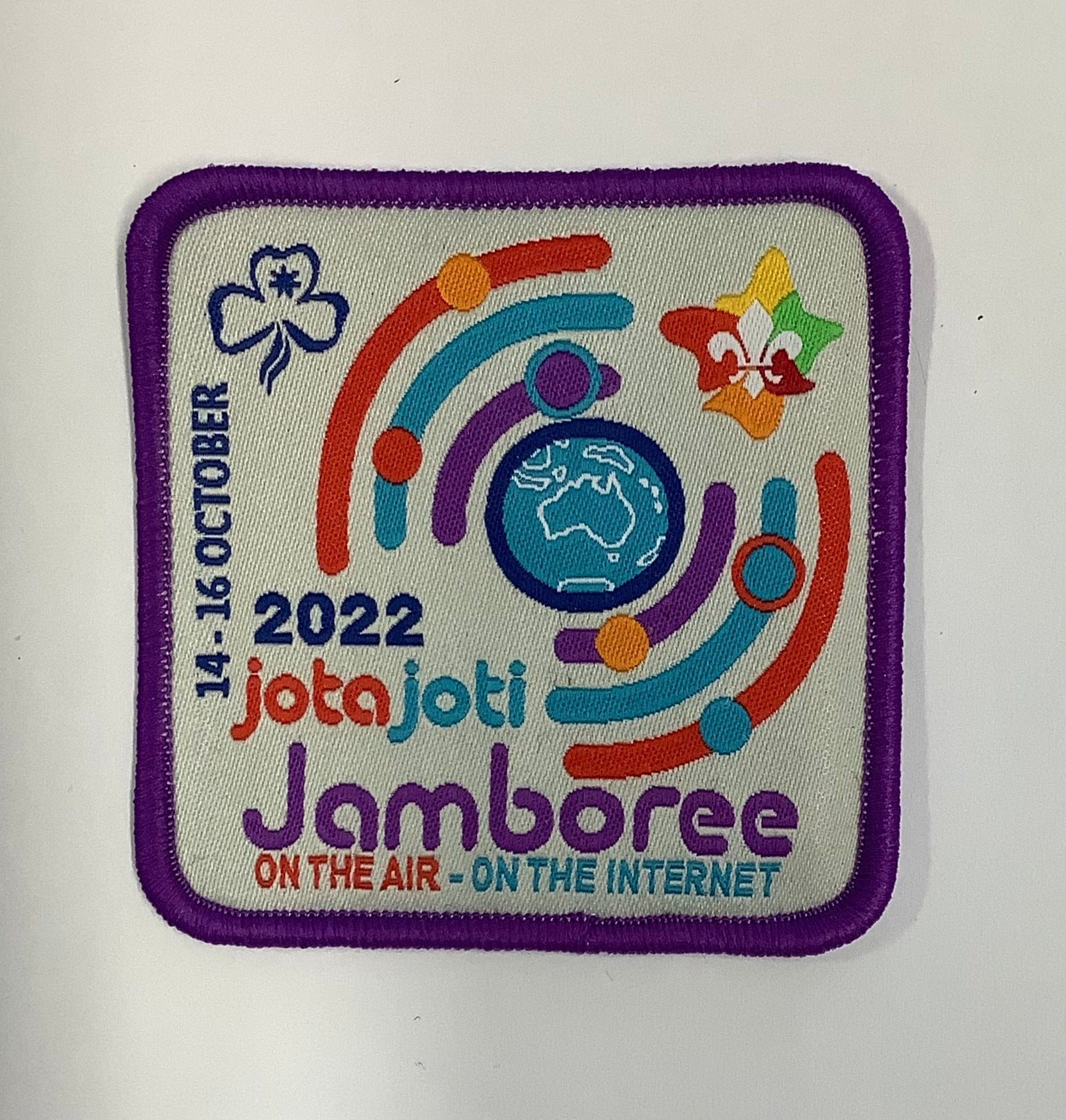 a square badge bound in purple with the globe and radio waves