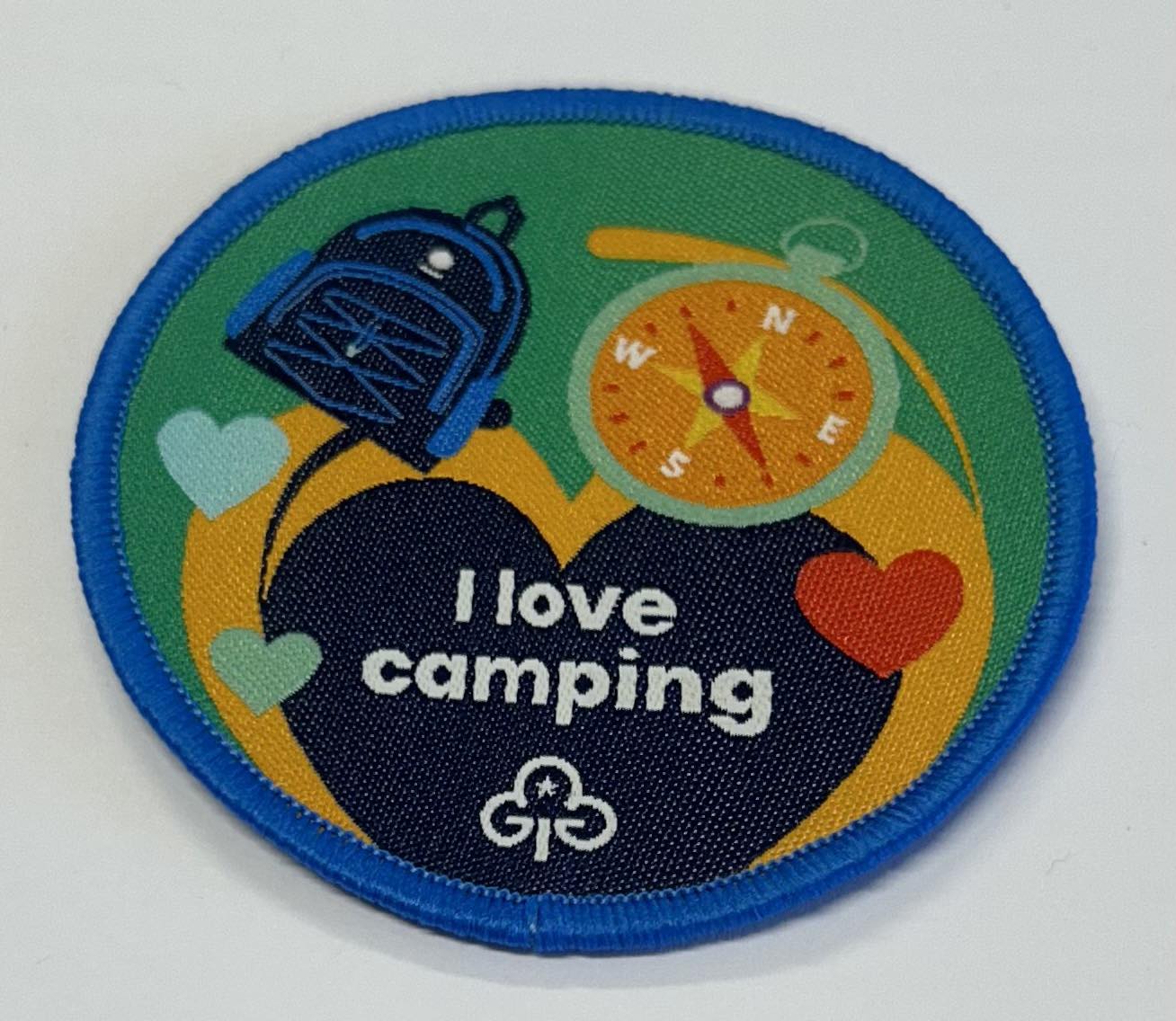 a round begs bound in royal blue with a backpack, compass and hearts and the words I love camping