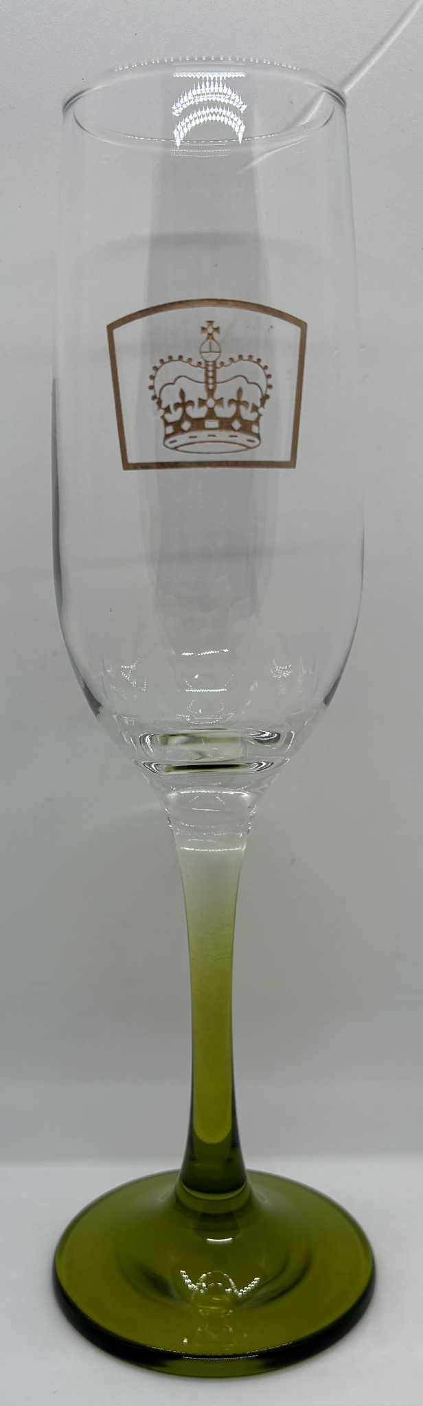 a champagne flute with the queens guide emblem etched in gold