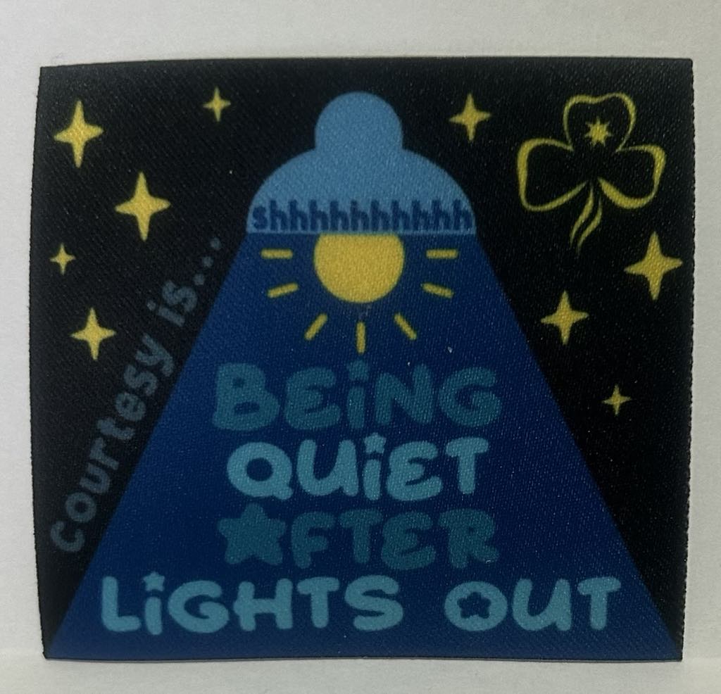 a square unbound badge that has a black background with a light emitting a blue shadow with the words courtesy is being quiet after lights out