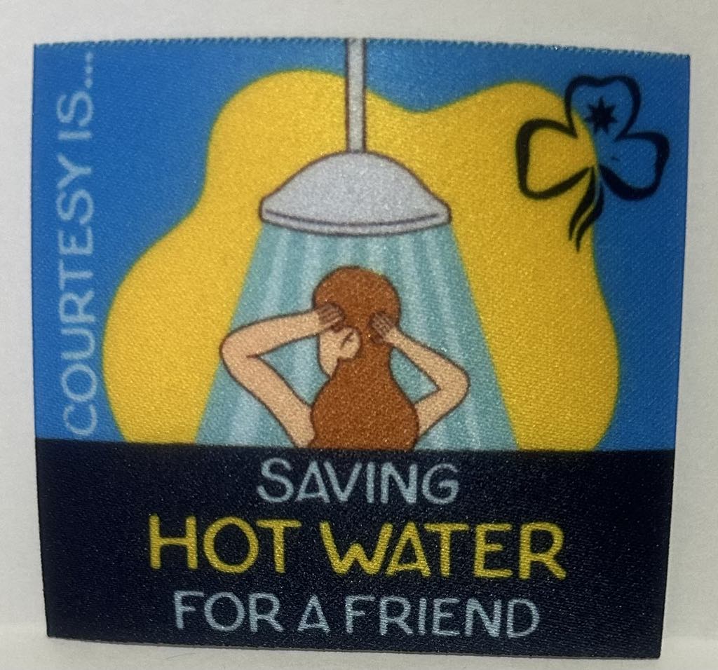 an unbound badge with a two tone blue background with a girl under a shower head with the words courtesy is saving hot water for a friend