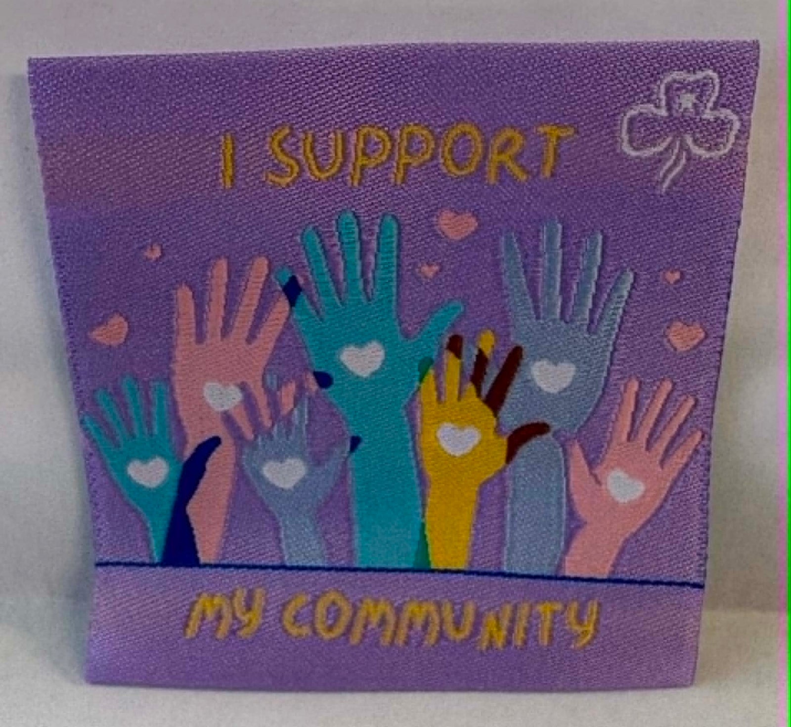 Purple square unbound badge with colourful hands and 'I Support My Community' text.