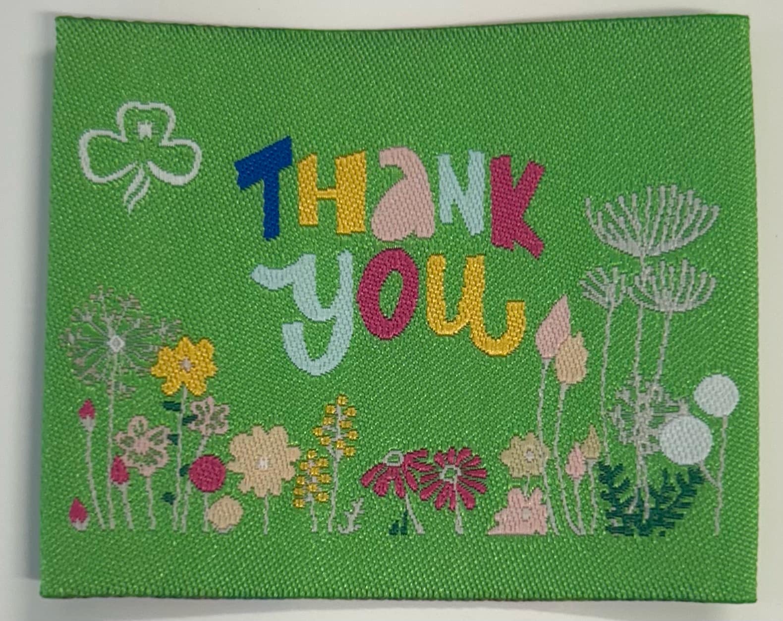 a green square unbound badge with flowers and the words thank you