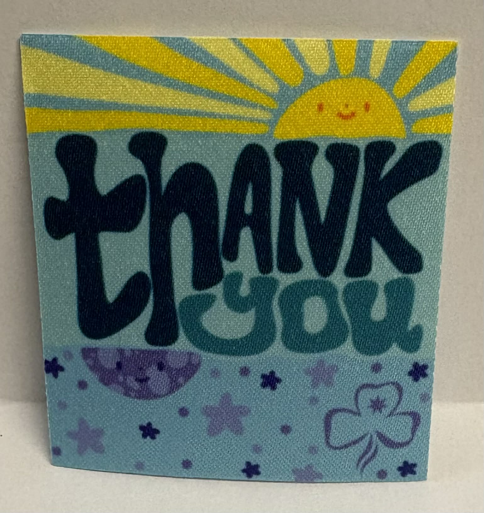 Square unbound badge with 'Thank You' text, sun, moon, and star illustrations on a blue background.