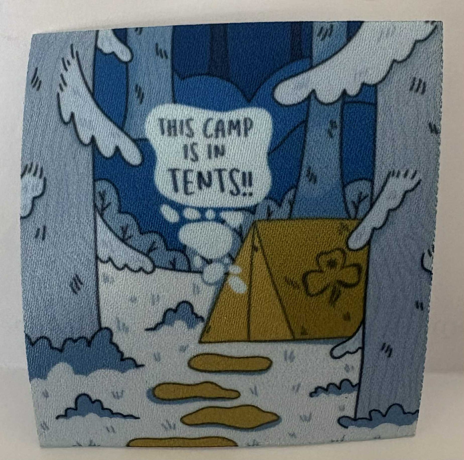 a square unbound badge with a Cartoon-style illustration of a campsite with tents in a snowy forest.
